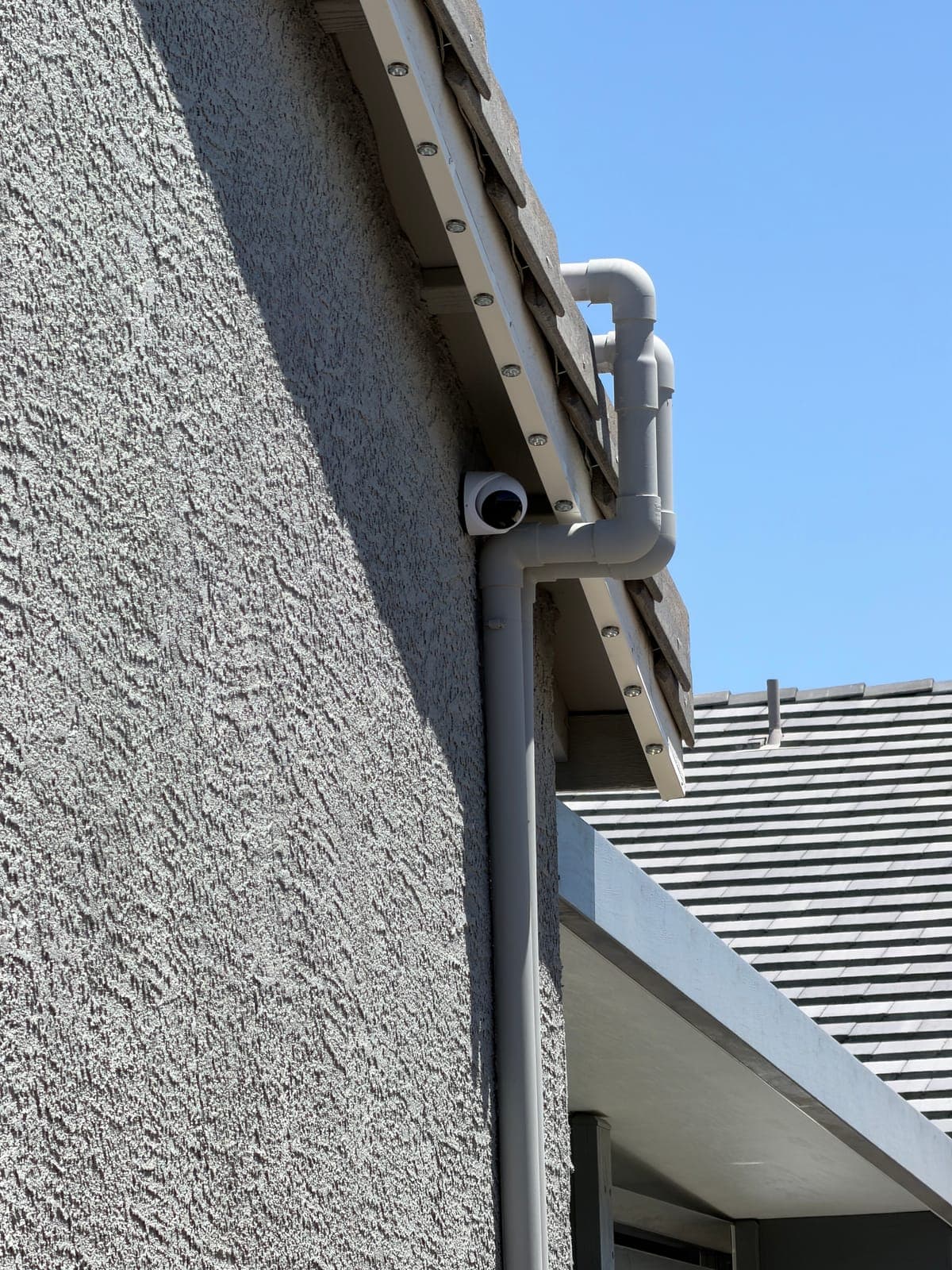 Hardwired UniFi Protect camera set under the eave to cover the driveway approach.